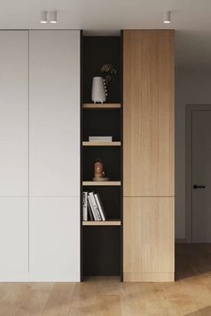 an empty room with some bookshelves in the corner and a lamp next to it