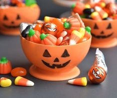 three orange bowls filled with candy and candies