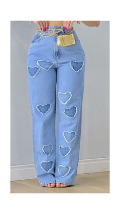 a woman is wearing blue jeans with hearts on them