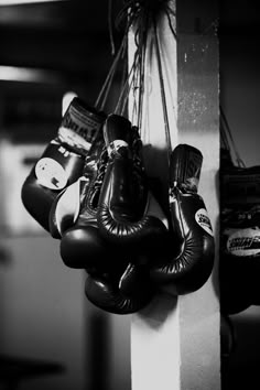 black and white photograph of boxing gloves hanging on wall