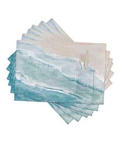 six place mats with forks and spoons on top of each one in the ocean