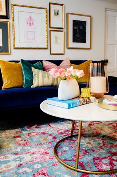 a living room filled with furniture and pictures on the wall above it's coffee table