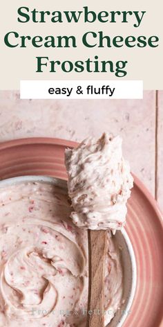 strawberry cream cheese frosting in a pink bowl with a wooden spoon on the side