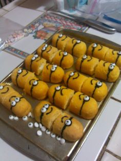 there are many rolls with eyes on them sitting on a baking sheet in the kitchen