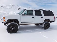 a white four - door suv parked in the snow