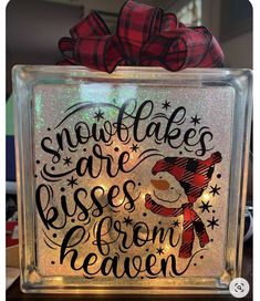 a lighted glass block with the words snowflakes are kisses from heaven on it