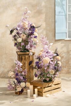 two vases with flowers and candles are sitting on the floor next to each other