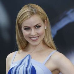 a woman in a blue and white dress posing for the camera with her hands on her hips