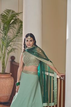 This 3-piece set features a green Titan Silk lehenga choli with 10 meters of flair and a Butterfly Net dupatta. It is standard cancan and canvas attached. The entire set is detailed with dori, mirror, zari and sequins embroidery. The blouse is sleeveless, round necked with back dori and tassels, and measures 0.8 meter. The lehenga is floor-length and flared. Dry-cleaning is recommended for this set. Customizations are available upon checkout; simply add your measurements in the “Order Notes” box Semi-stitched Green Lehenga With Pallu, Green Semi-stitched Lehenga For Diwali, Green Floor-length Lehenga For Festive Occasions, Festive Green Floor-length Lehenga, Green Semi-stitched Choli With Dupatta, Green Semi-stitched Lehenga With Dupatta, Semi-stitched Green Lehenga With Dupatta, Green Lehenga With Zari Work For Navratri, Green Semi-stitched Lehenga For Festivals