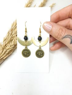 Egyptian Eye of Horus Earrings 🌿 . This pair is made of brass parts. No Nickel No Lead . . The item will arrive at you wrapped as a gift in a paper gift bag. . Here are some tips to ensure longevity with my pieces: 》 Avoid showering, swimming, and exercising with my pieces. 》 Avoid wearing perfumes with your jewelry. 》 Avoid sleeping with your pieces on.  》 When not in use, store items in a box. . 》SHIPPING: If you need a tracking number for your order change the shipping option before checkout Handmade Symbolic Drop Earrings, Spiritual Bronze Drop Earrings, Handmade Symbolic Black Earrings, Spiritual Bronze Dangle Earrings, Bronze Spiritual Earrings As Gift, Spiritual Bronze Earrings Gift, Handmade Symbolic Earrings, Handmade Symbolic Round Earrings, Symbolic Handmade Round Earrings