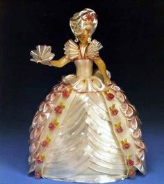 the figurine is wearing a white dress with red flowers on it's skirt