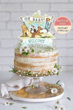 a winnie the pooh birthday cake with flowers and greenery on top is shown in front of a brick wall