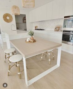 a kitchen with an island and stools next to the counter top in front of it