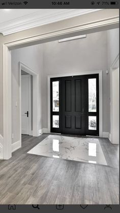 an empty room with two black doors and white trim on the walls is seen in this image