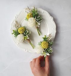 a person is holding flowers on a plate