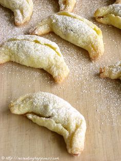 several pastries on a wooden surface covered in powdered sugar