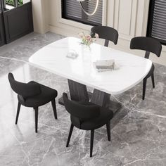 a white marble dining table with four black chairs in front of it and a window