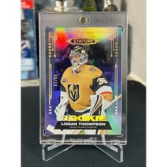 the hockey card is on display in a clear acrylic holder with an image of goalie loon thompson