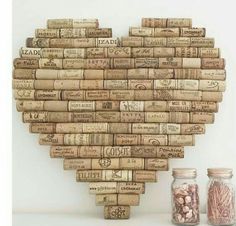 a heart made out of wine corks with jars around it and the words love spelled on them