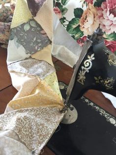 a close up of a sewing machine on a table with flowers in the back ground