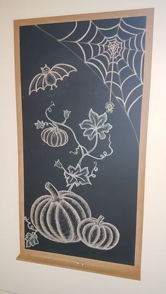 a chalkboard with pumpkins and spider web on it