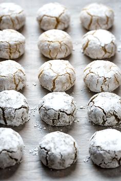 many cookies are covered in powdered sugar on a baking sheet, ready to be baked