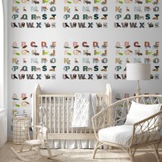 a baby's room with alphabet wallpaper and rocking chair in front of the crib