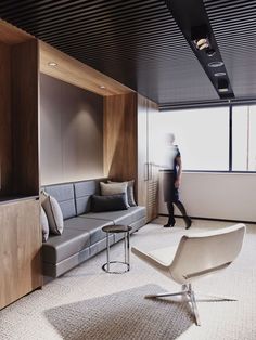 a man walking through an office lobby next to a couch