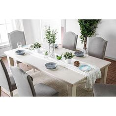 a dining room table with chairs and plates on it