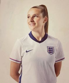 a woman in a soccer uniform poses for a photo