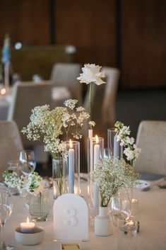 the table is set with candles, flowers and vases for an elegant wedding reception