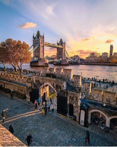 the tower bridge in london is lit up at sunset