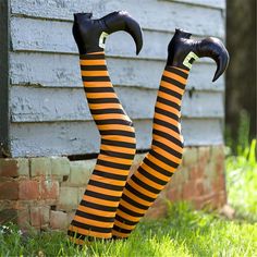 a woman in black and orange striped tights laying on the ground with her legs up