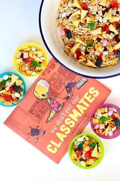 the cereal salad is next to two bowls of cereal and a cookbook on a white table