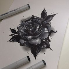 a drawing of a black rose with leaves on it and two markers next to it