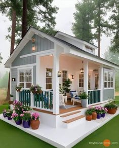 a small house with potted plants on the porch