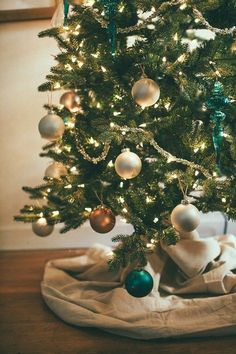 a small christmas tree with white and green ornaments