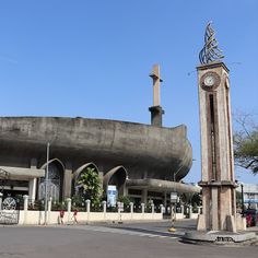 a large clock tower sitting next to a tall building with a massive structure on it's side