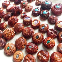 many different types of wooden buttons on a white surface with blue eyes and green beads