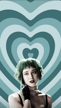 a woman with green hair is holding her hand up to her face in front of a heart - shaped background