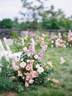 a bouquet of flowers sitting on top of a white chair next to a lush green field