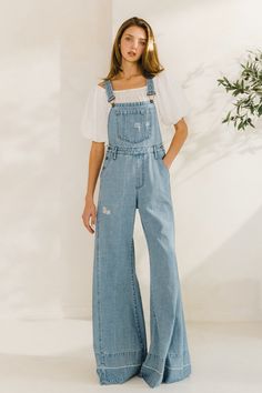 Choose comfort and style with the Women's Distressed Wide Leg Denim Overall. The adjustable straps, kangaroo chest pocket, and front and back pockets provide convenience, while the wide western legs, side buttons, and distressed accents add a trendy touch. Stay on trend in these comfortable, boho-inspired overalls. 34" INSEAM SLEEVELESSBUCKLE CLOSUREADJUSTABLE STRAPSKANGAROO CHEST POCKETFRONT/BACK POCKETSWIDE LEG Coastal Cowgirl Overalls, Wide Leg Denim Overalls, Women’s Overall Outfits, Denim Party Outfit For Women, Boho Overalls Outfits, Overall Outfits Women, Aesthetic Denim Outfits, Jean Overall Dress Outfit, Simple Outfit Aesthetic