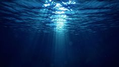 the sun shines brightly through the water's blue ocean floor, making it appear to be underwater