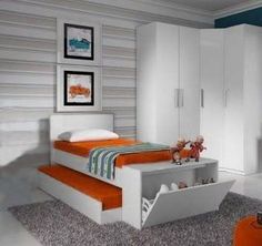 a bedroom with a bed, dresser and two pictures on the wall above it in orange and white