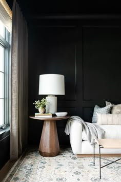 a living room with black walls and white furniture