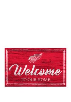 a wooden sign that says welcome to our home with the detroit red wings on it