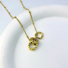 Make a bold statement with our Three Circles Pendant Necklace! This eye-catching necklace features three unique rings – one adorned with shimmering green stones, one with an irregular design, and one in classic gold. Together, they create a harmonious and stylish piece that effortlessly elevates any outfit. Chic Gold Necklaces With Gemstone, Chic Gold Necklace With Gemstone, Modern Gold Necklace With Birthstone, Latina Culture, Green Stones, Circle Pendant Necklace, Classic Gold, Circle Pendant, Gold Pendant Necklace