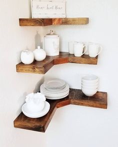 the shelves are made out of wood and have plates, cups, and mugs on them