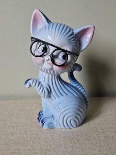 a cat figurine wearing glasses sitting on top of a table