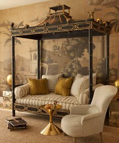 a canopy bed sitting in the middle of a living room next to a white couch